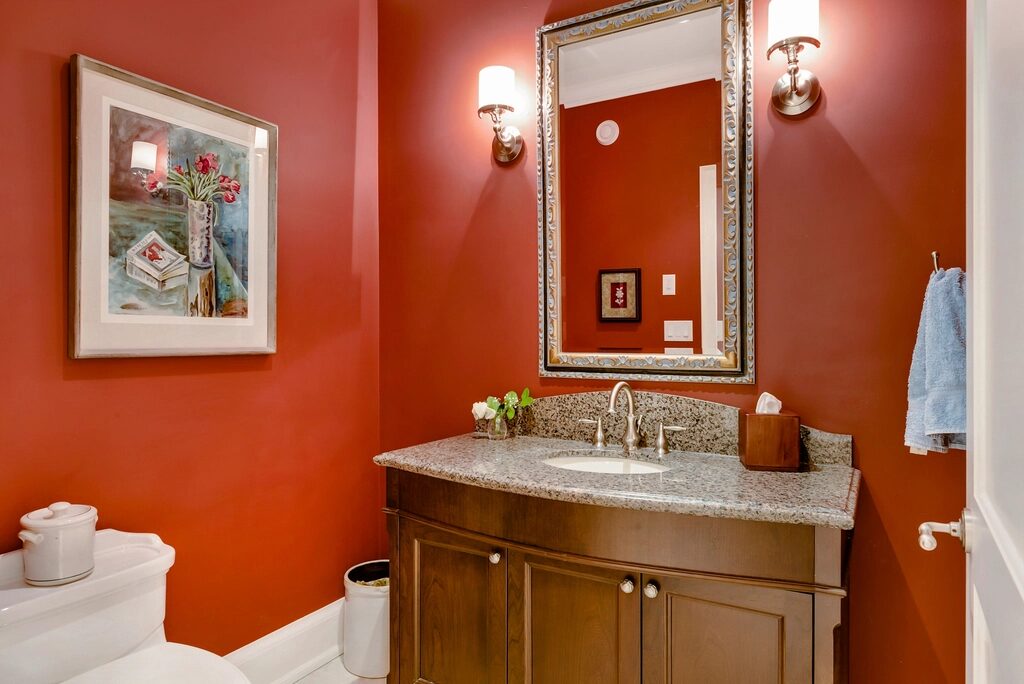 Warm bathroom interior with wall lights beside a mirror