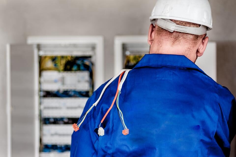 Electrician facing an open electrical panel