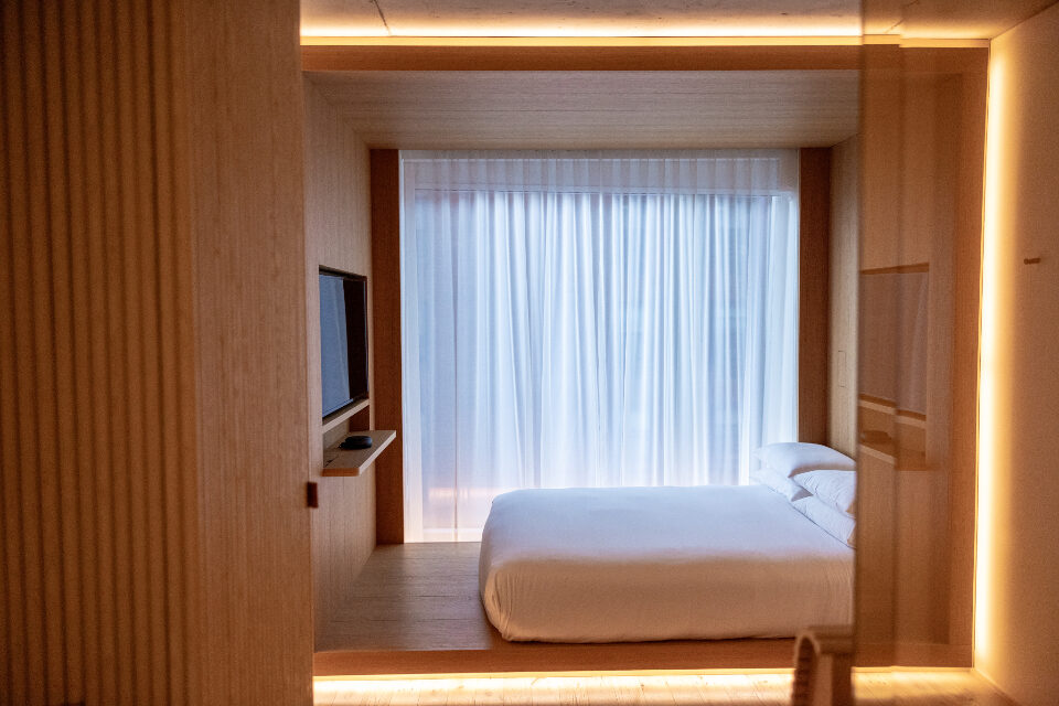 Made bed in a calm room with sheer curtains