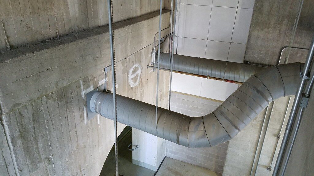 Insulated ductwork running across a concrete ceiling