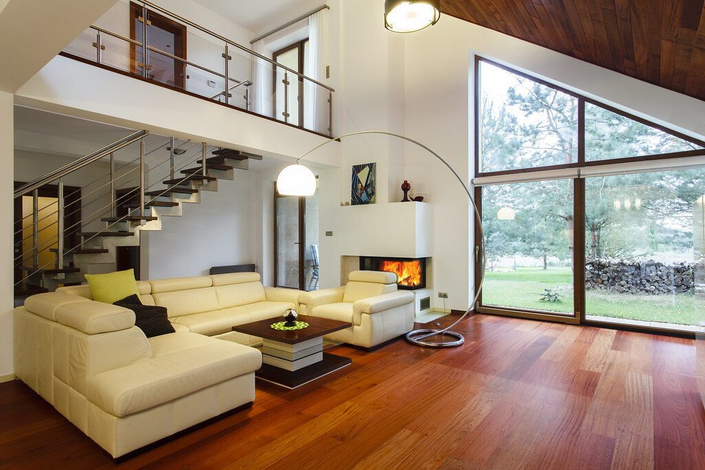 A bright living room with tall windows and a sectional sofa