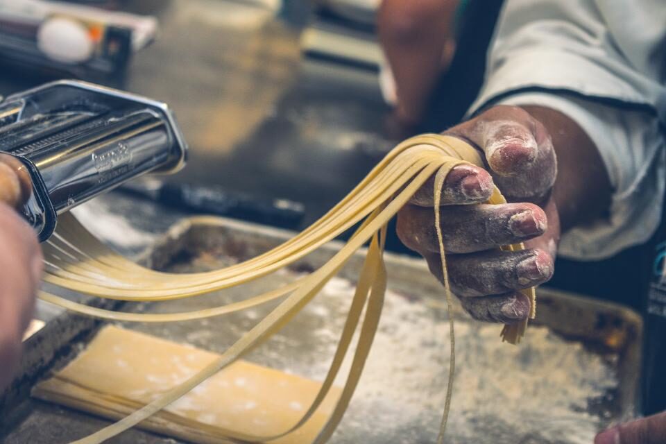 Fresh pasta being shaped by hand